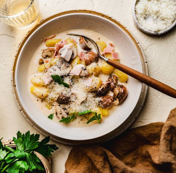 Gnocchi w sosie serowym z szynką i pieczarkami