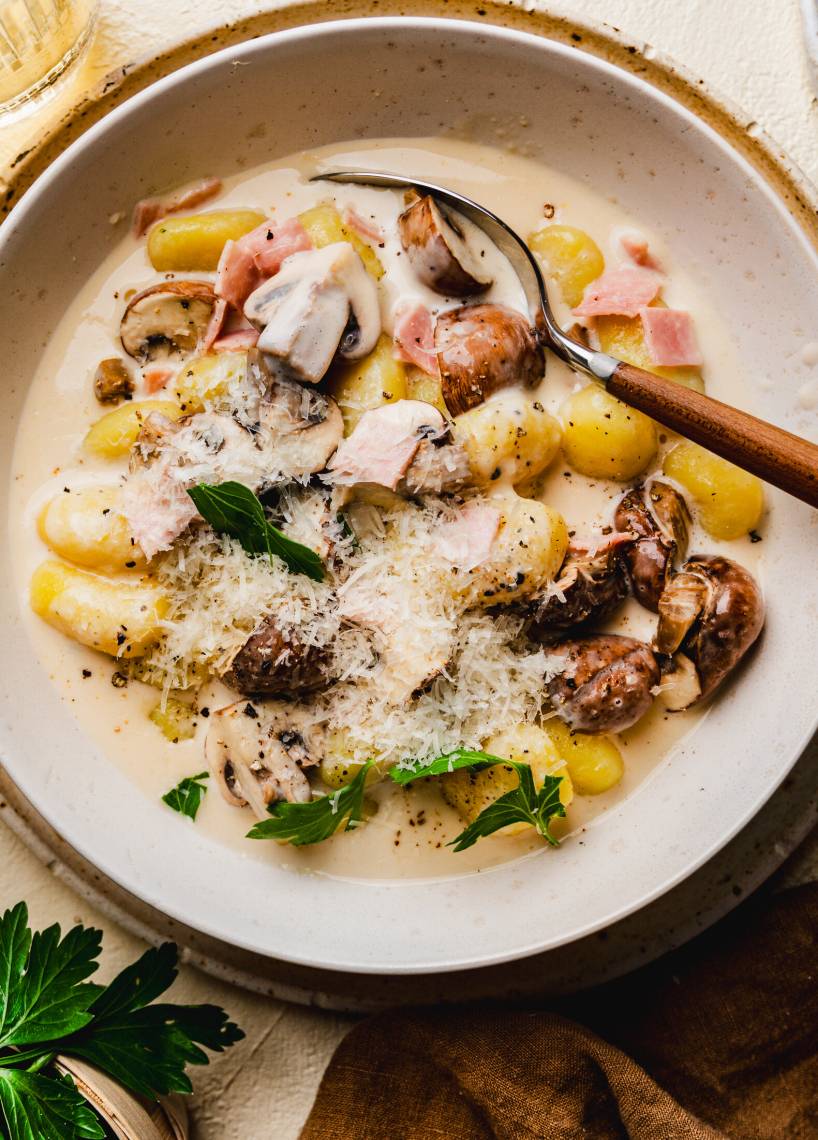 Gnocchi w sosie serowym z szynką i pieczarkami